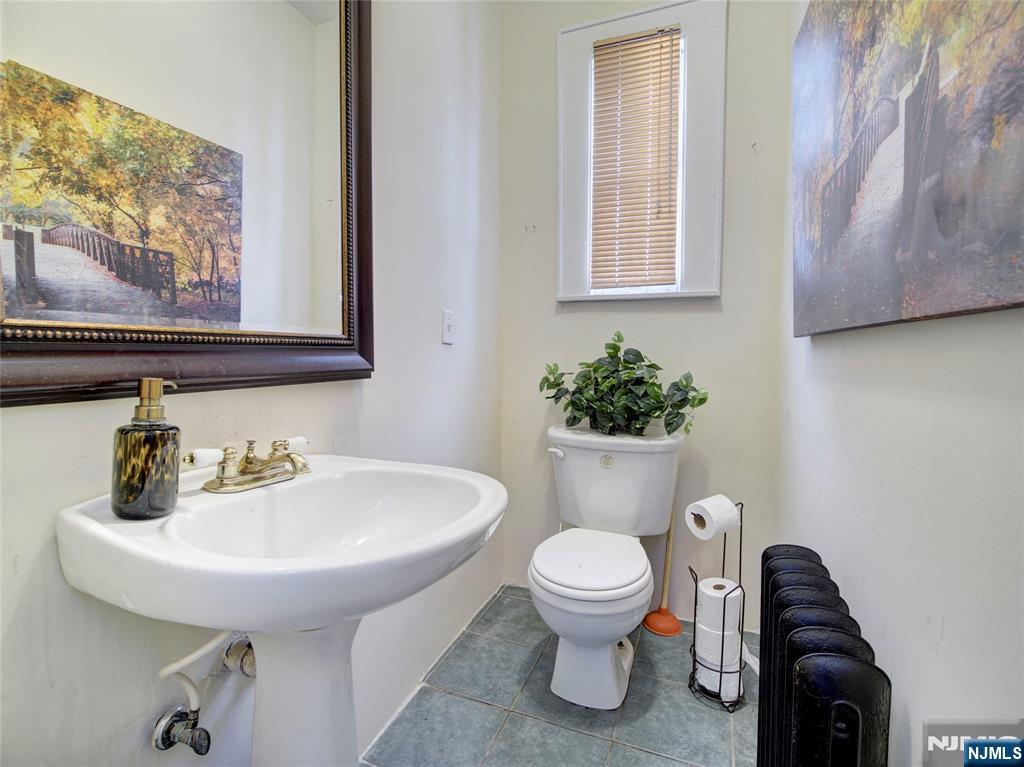 5 Park Road Paterson, NJ 07514 - Photo 11 of 30 a bathroom with a toilet sink and mirror