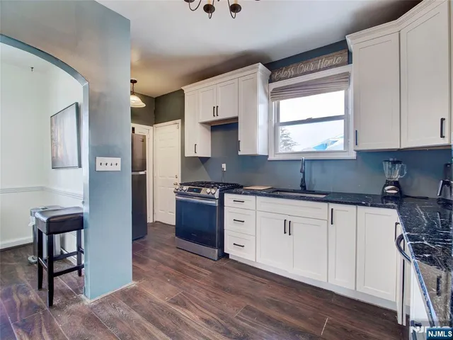 a kitchen with stainless steel appliances granite countertop a stove a sink and a refrigerator