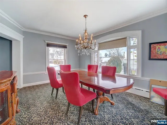 a dining room with furniture a chandelier and window