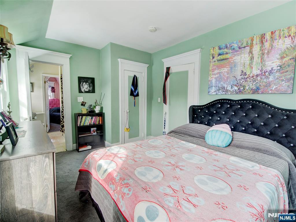 5 Park Road Paterson, NJ 07514 - Photo 22 of 30 a bedroom with a bed and dresser with mirror