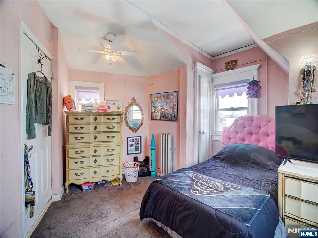 5 Park Road Paterson, NJ 07514 - Photo 24 of 30 a bedroom with a bed and a chandelier