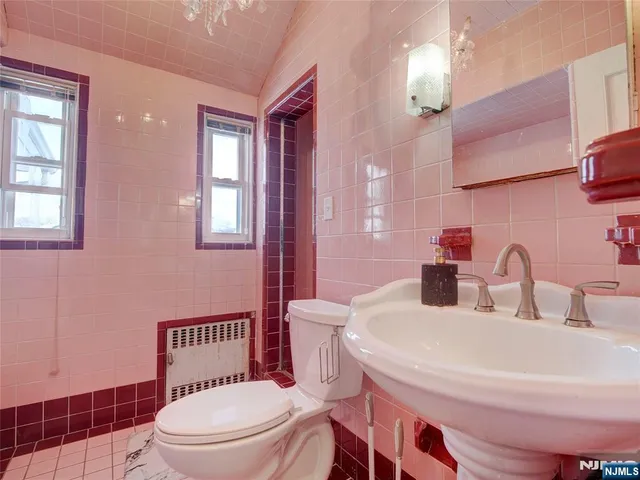 a bedroom with a bed and dresser with mirror