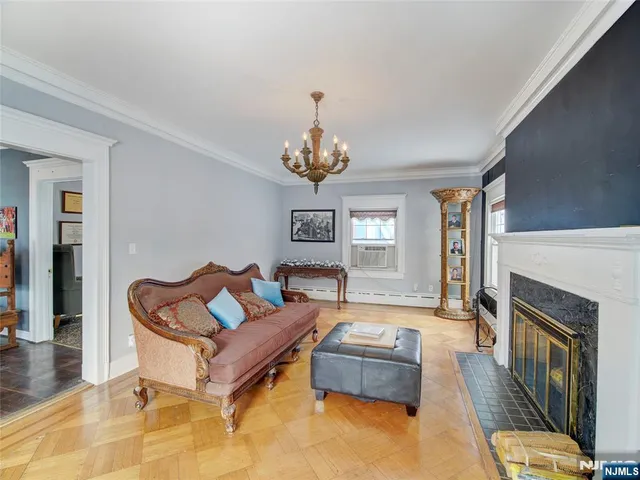 a living room with furniture a fireplace and a chandelier