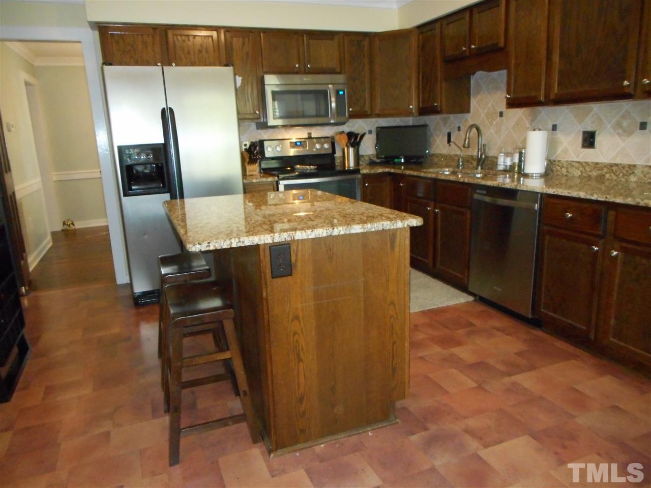 2616 Howard Road Raleigh, NC 27613 - Photo 5 of 16 a kitchen with stainless steel appliances granite countertop a refrigerator a stove and a sink