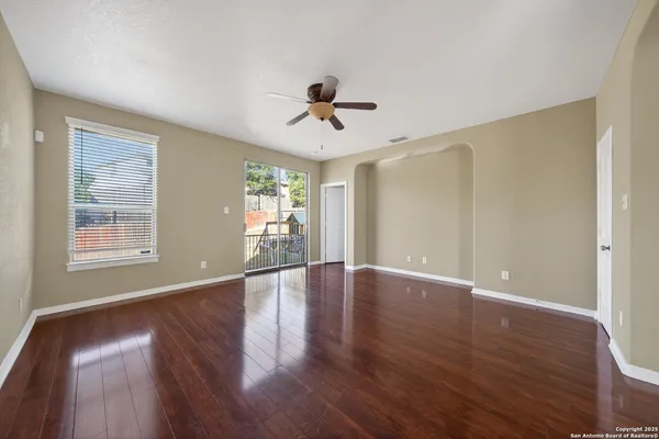a view of a livingroom with wooden floor and a ceiling fan