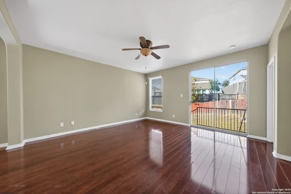 a view of a room with wooden floor and a ceiling fan