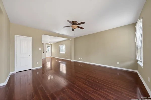 a view of a livingroom with wooden floor and a ceiling fan