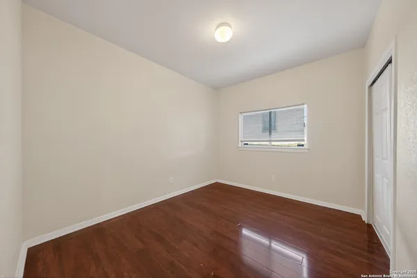 a view of a room with wooden floor and window