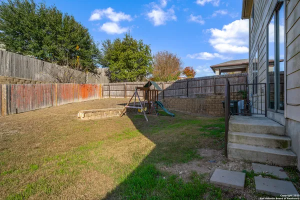 a view of backyard with cabin and wooden fence