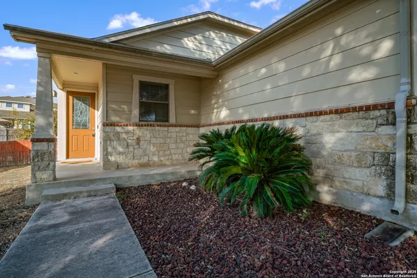 a view of a hallway with wooden floor and a bathroom