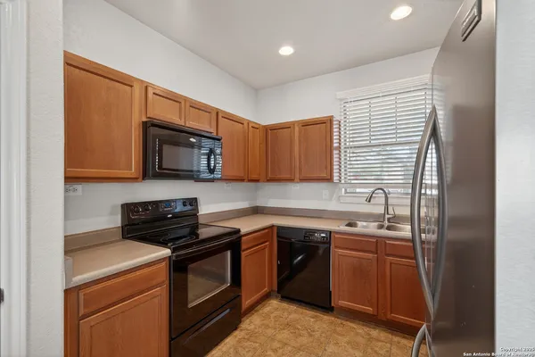 a kitchen with stainless steel appliances granite countertop white cabinets and black appliances