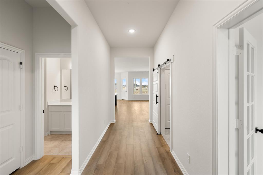 125 Snowy Owl Trail Rhome, TX 76078 - Photo 4 of 28 Corridor featuring a barn door, light wood finished floors, and recessed lighting