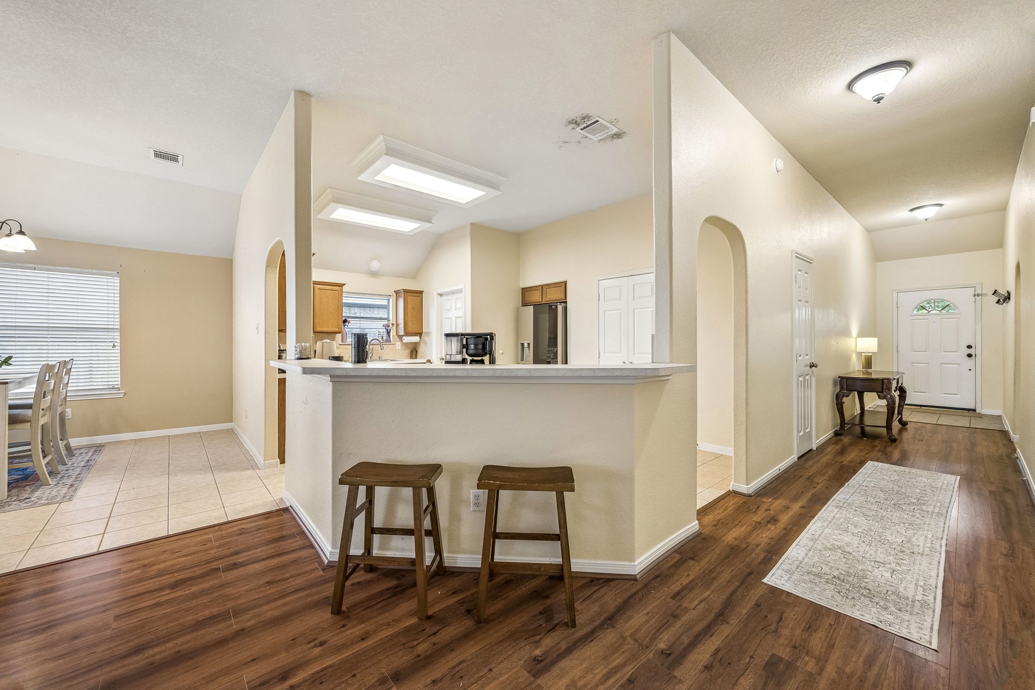24027 Floragate Drive Spring, TX 77373 - Photo 11 of 21 a living room with kitchen island granite countertop wooden floor and a dining table with kitchen view