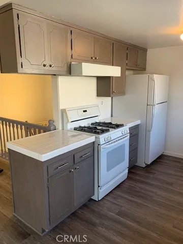 a kitchen with stainless steel appliances a white stove top oven and refrigerator