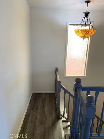 a view of staircase with wooden floor and chair