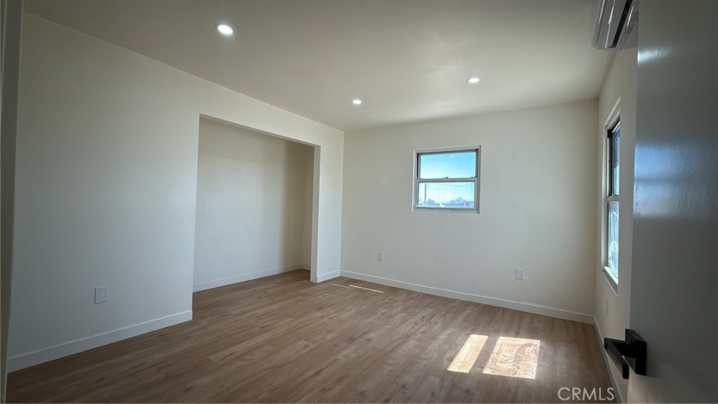 716 West Church Avenue Ridgecrest, CA 93555 - Photo 6 of 13 an empty room with wooden floor and windows