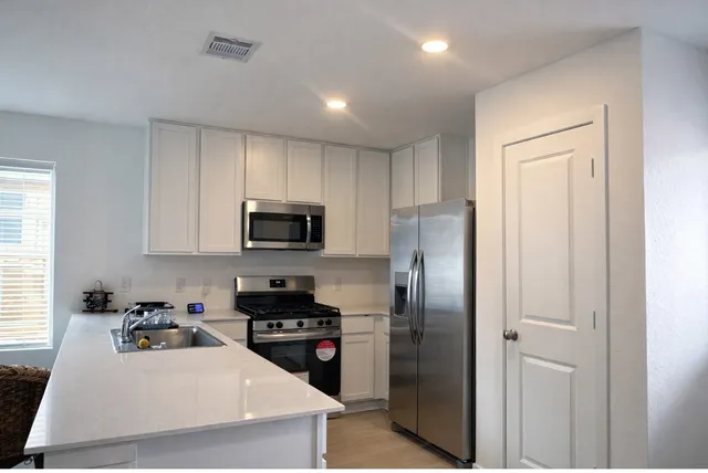 a kitchen with a sink stainless steel appliances and refrigerator