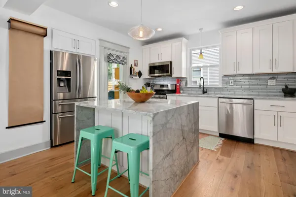 a kitchen with stainless steel appliances a microwave a sink a stove a table and chairs