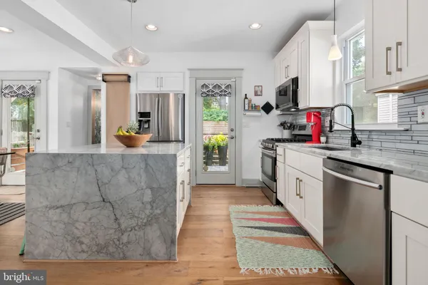 a kitchen with stainless steel appliances granite countertop a refrigerator and a stove