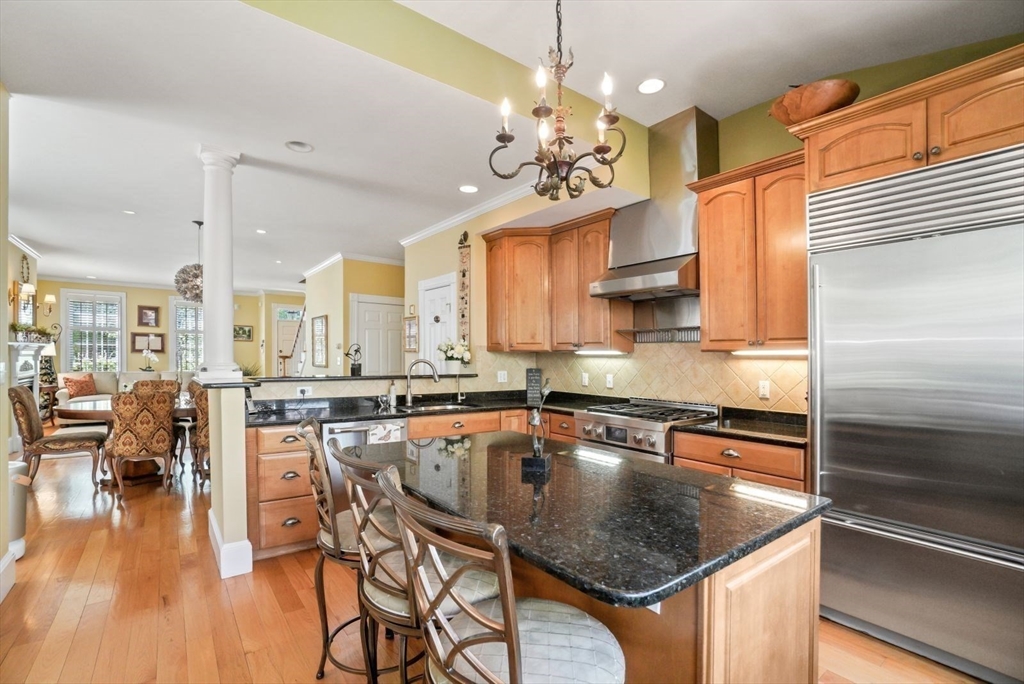 65 Rutherford Avenue Boston, MA 02129 - Photo 4 of 25 a kitchen with stainless steel appliances granite countertop a stove top oven a dining table and chairs with wooden floor