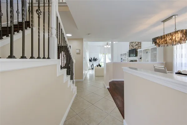 a hallway with a dining table chairs and a refrigerator