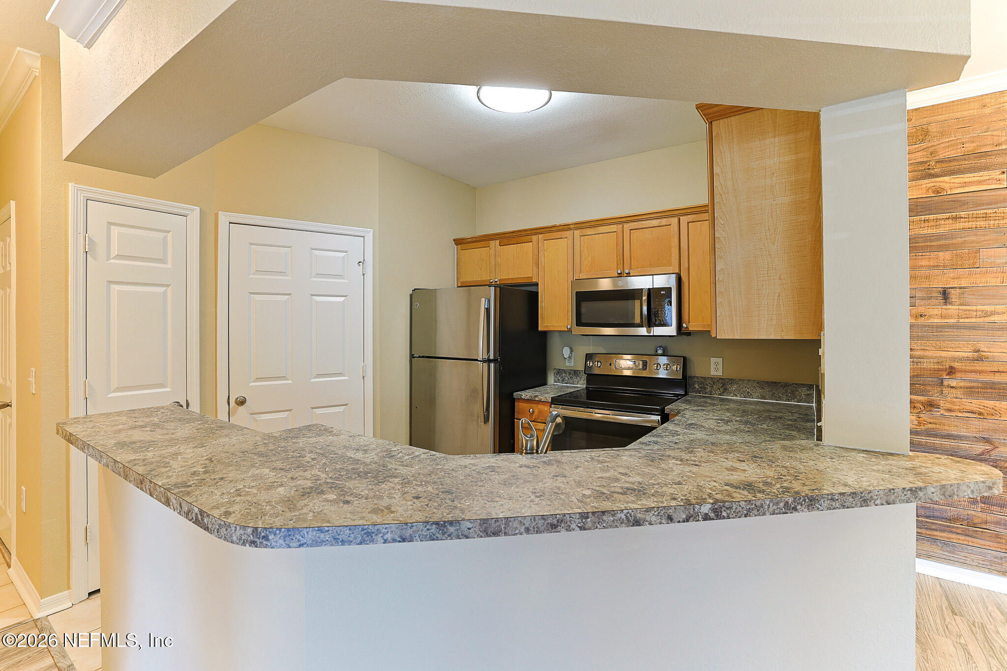 10961 Burnt Mill Road, Unit 426 Jacksonville, FL 32256 - Photo 6 of 24 a kitchen with kitchen island granite countertop a sink and a refrigerator