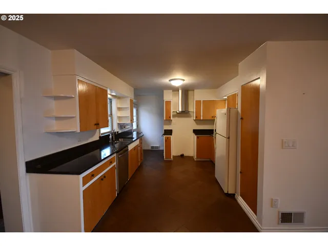 a kitchen view with stainless steel appliances a refrigerator and a stove