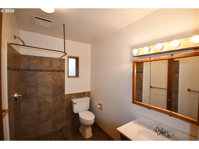 a bathroom with a toilet a sink and shower