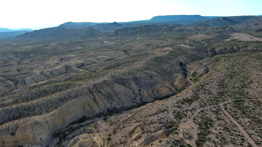100 Needle Peak Road Terlingua, TX 79852 - Photo 9 of 20 a view of a dry yard with mountains in the background