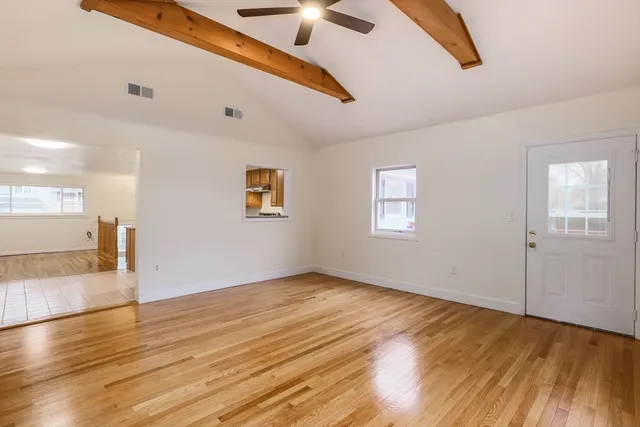 a view of an empty room with wooden floor