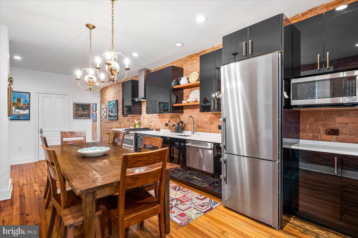 338 East Church Street Frederick, MD 21701 - Photo 13 of 54 a kitchen with stainless steel appliances granite countertop a refrigerator a sink dishwasher a dining table and chairs with wooden floor