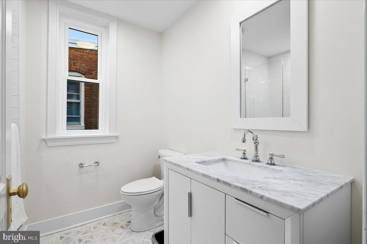 338 East Church Street Frederick, MD 21701 - Photo 19 of 54 a bathroom with a granite countertop sink a toilet and a mirror