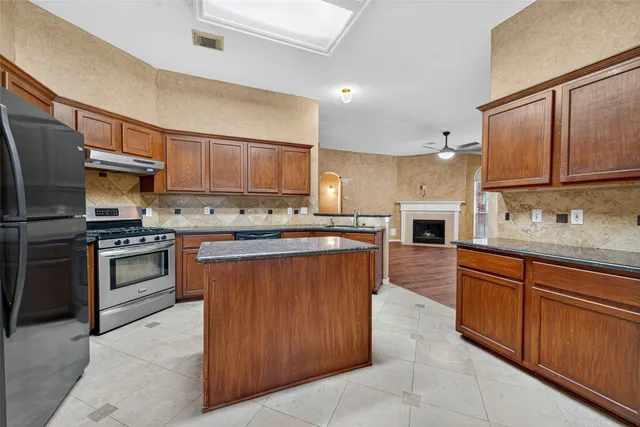 a kitchen with stainless steel appliances granite countertop a stove refrigerator sink and cabinets