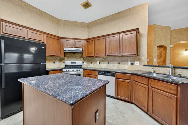 a kitchen with kitchen island granite countertop a sink and cabinets