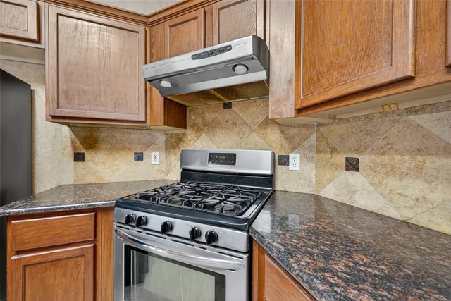 a kitchen with granite countertop stainless steel appliances and cabinets