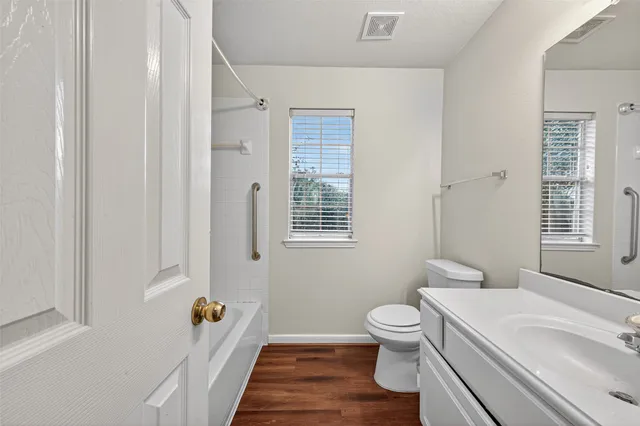 a bathroom with a sink a toilet and a window