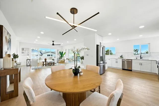 a living room with couches and kitchen view with wooden floor