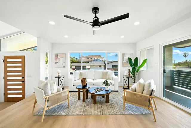 a living room with furniture a window and a ceiling fan
