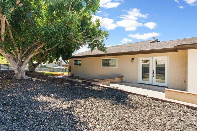 a backyard of a house with barbeque oven table and chairs