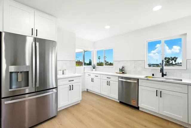 a kitchen with white cabinets and stainless steel appliances