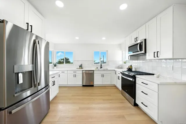 a kitchen with stainless steel appliances a refrigerator sink and microwave