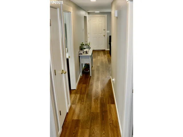 a view of a hallway with wooden floor