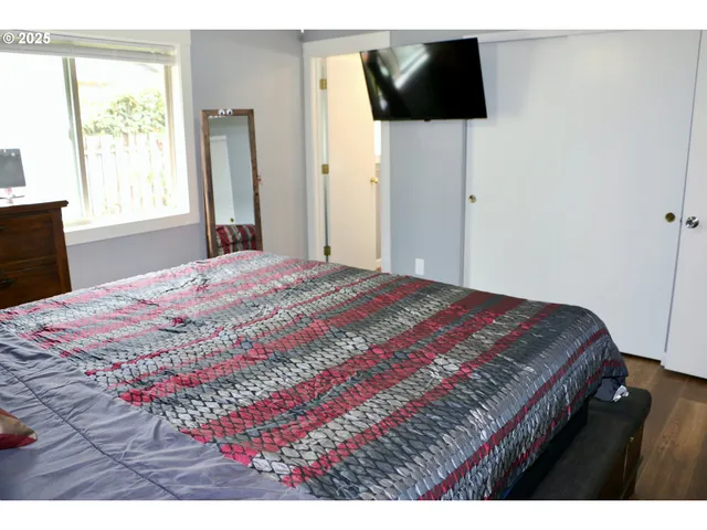 a bedroom with a bed and flat screen tv