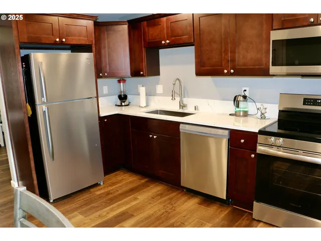 a kitchen with stainless steel appliances granite countertop a refrigerator stove a sink and dishwasher