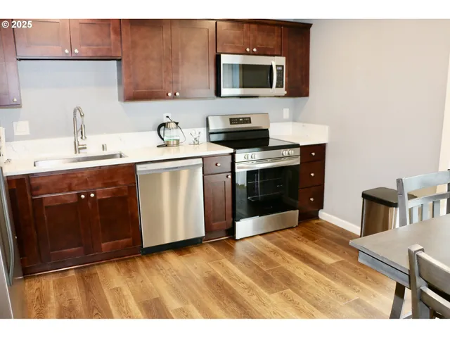 a kitchen with stainless steel appliances a sink and cabinets