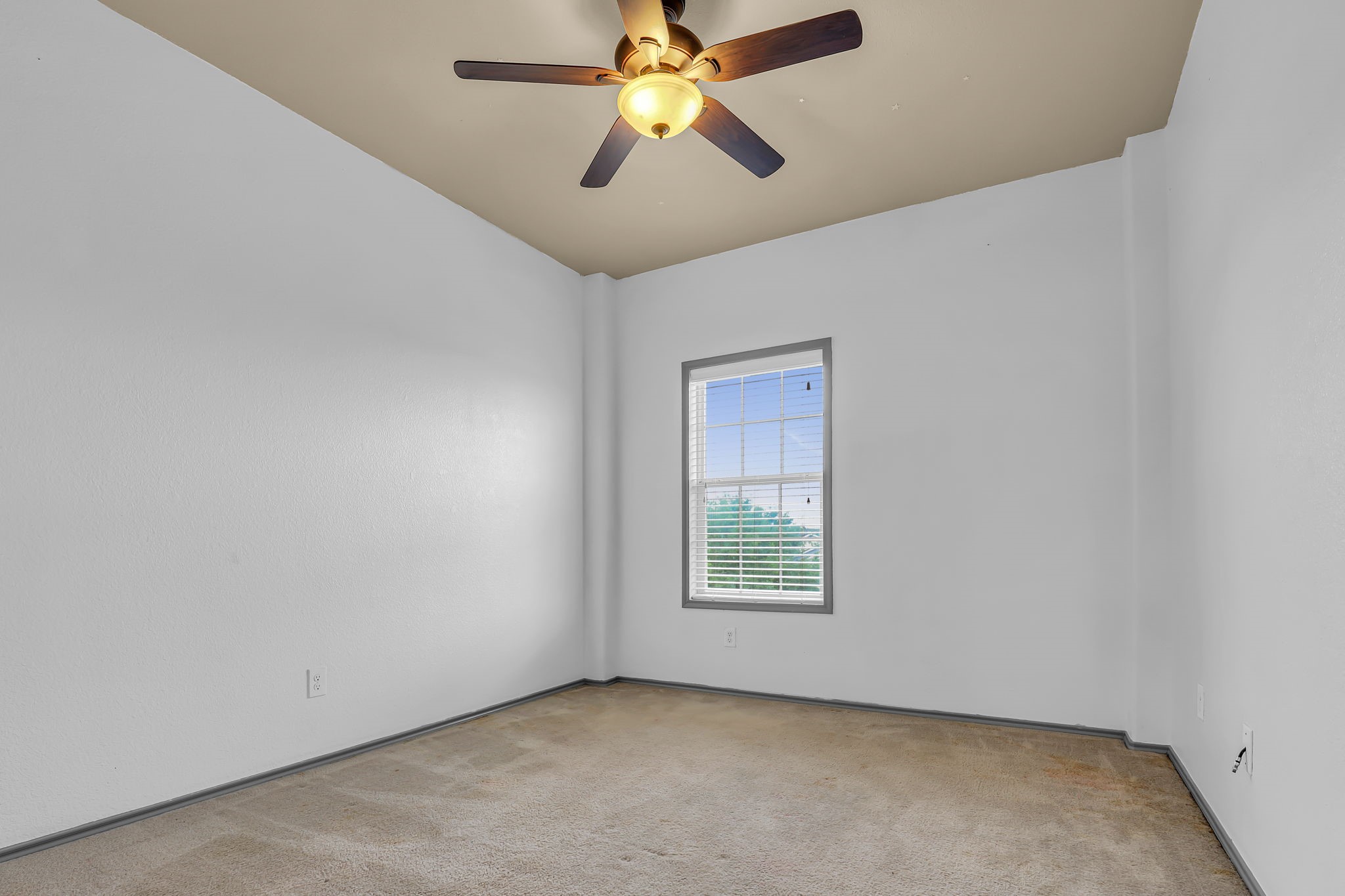 21307 Carleen Creek Trail Spring, TX 77379 - Photo 10 of 25 Bedroom features neutral walls, a ceiling fan with light, and a window providing natural light. The carpeted floor adds warmth and comfort. Ideal for use as a bedroom or office space.