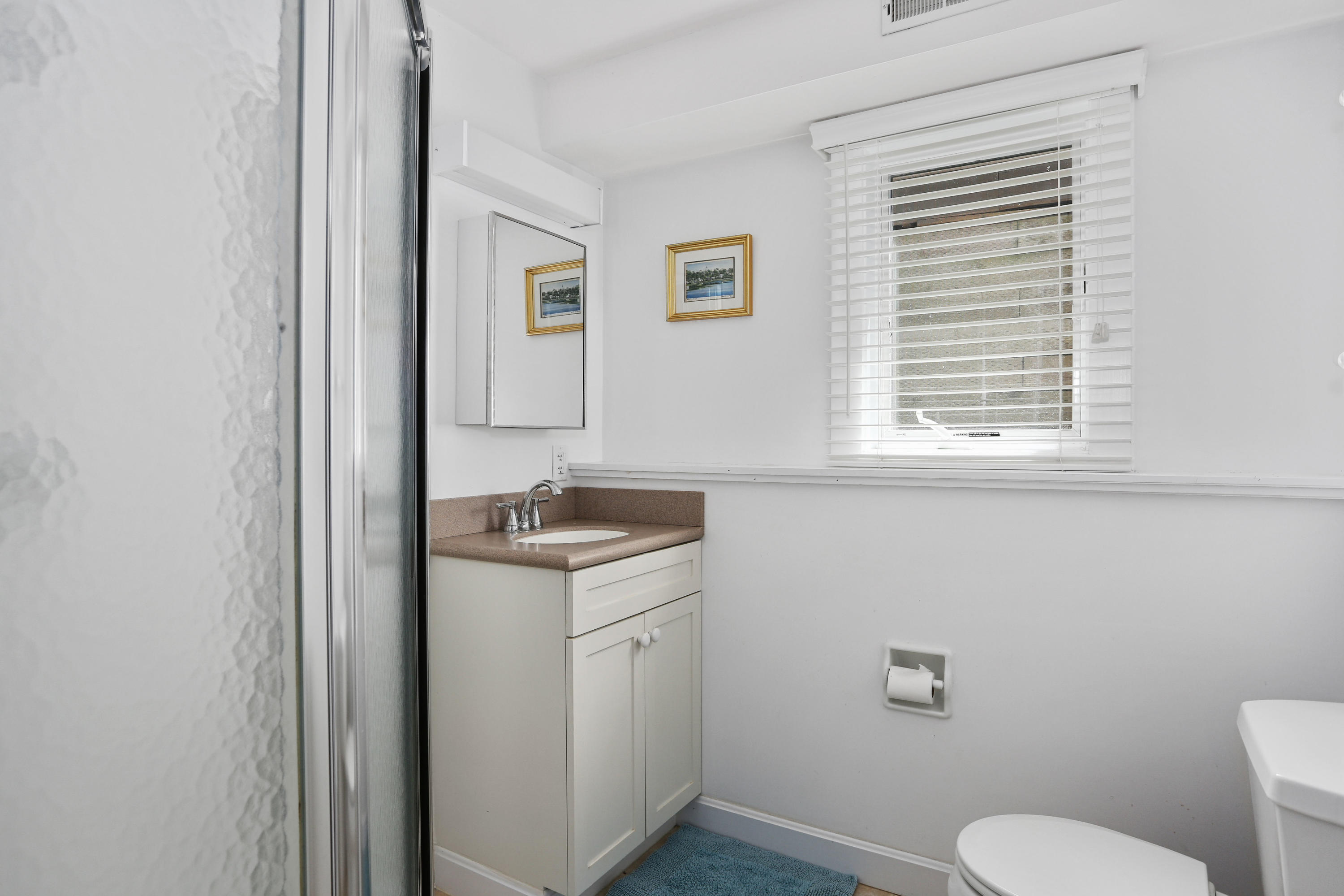 137 Nauhaught Bluff Road Wellfleet, MA 02667 - Photo 27 of 33 a bathroom with a granite countertop toilet a sink and a window