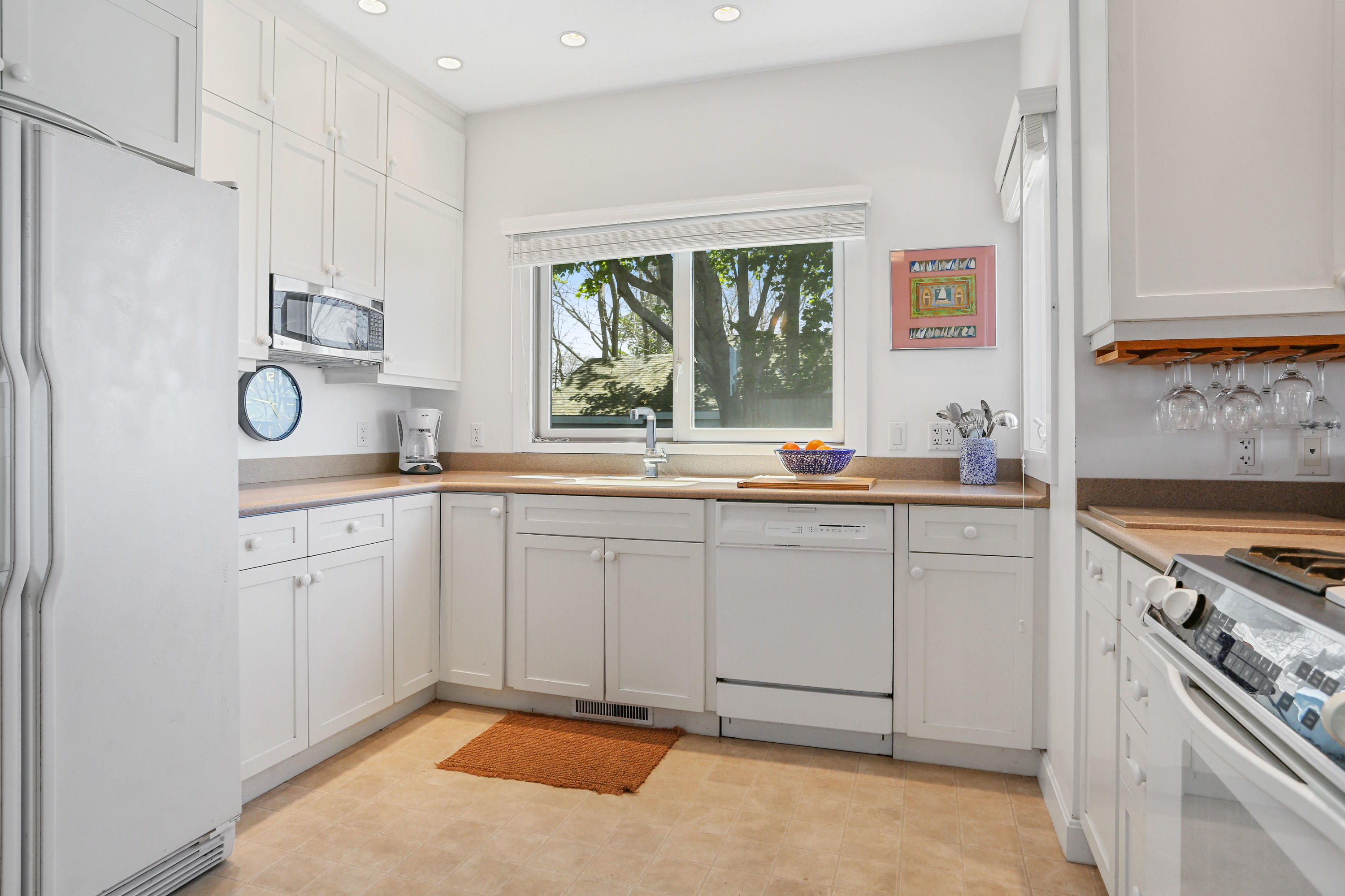 137 Nauhaught Bluff Road Wellfleet, MA 02667 - Photo 6 of 33 a kitchen with white cabinets and white appliances