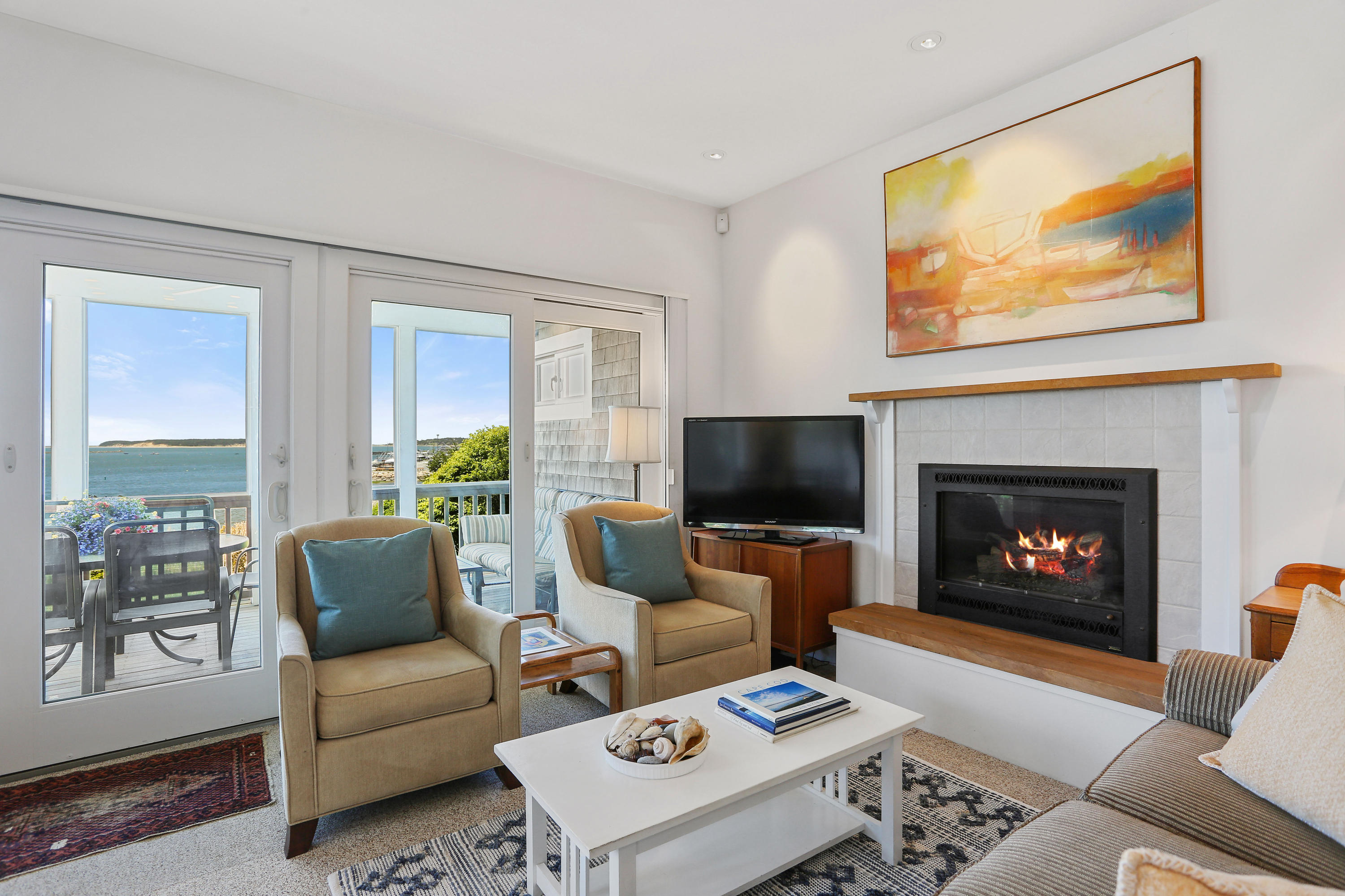 137 Nauhaught Bluff Road Wellfleet, MA 02667 - Photo 8 of 33 a living room with furniture a flat screen tv and a fireplace