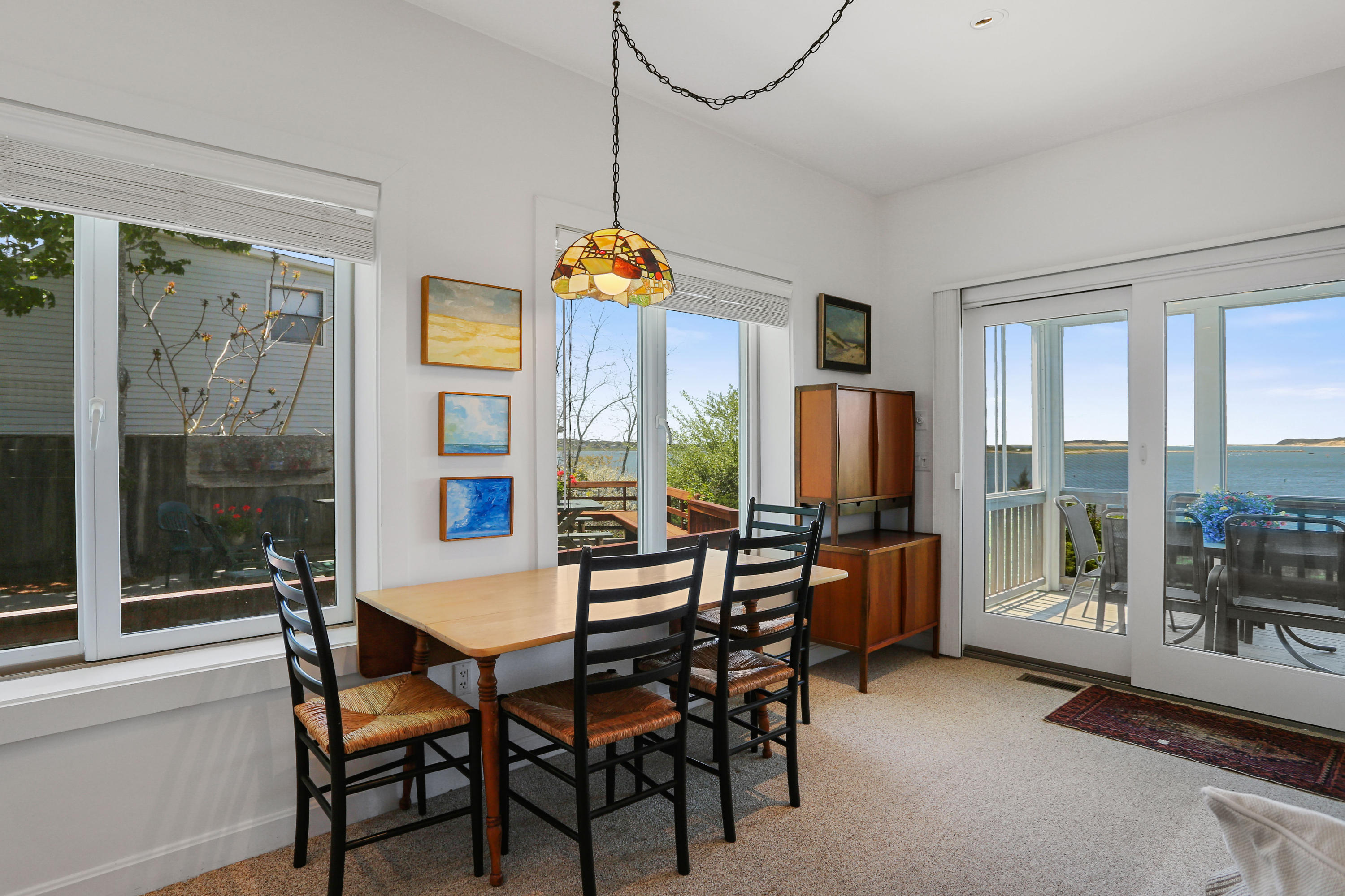 137 Nauhaught Bluff Road Wellfleet, MA 02667 - Photo 9 of 33 a dining room with furniture and a floor to ceiling window
